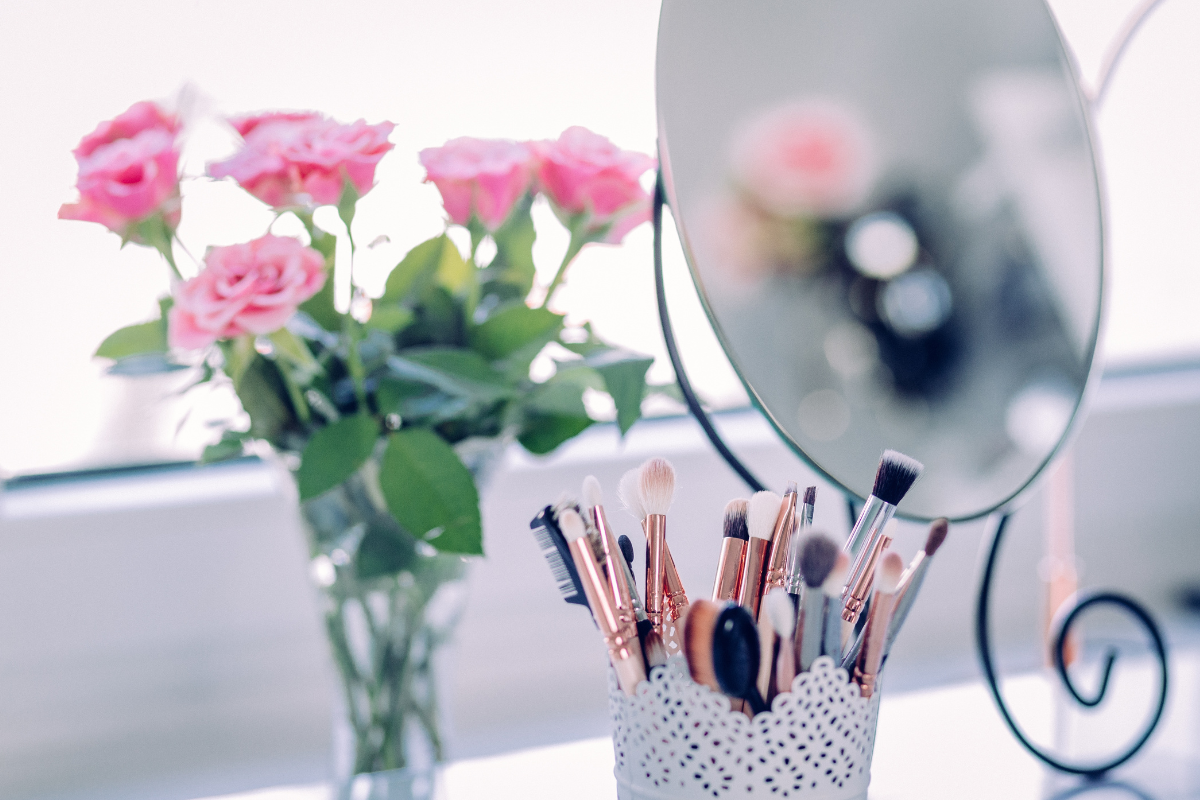 Schminkspiegel, Rosen und Make-Up-Pinsel